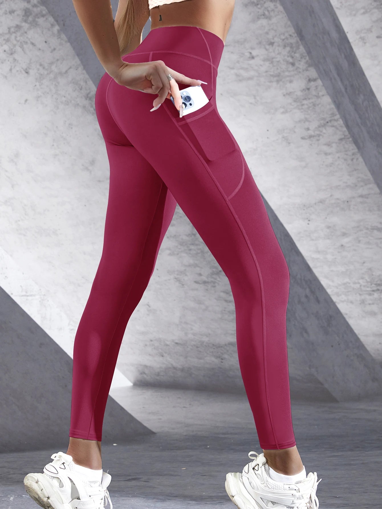 Person wearing pink leggings with a gray concrete background