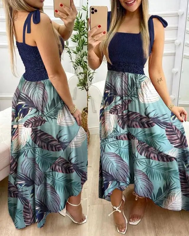 Woman wearing a blue and green patterned dress taking a mirror selfie.