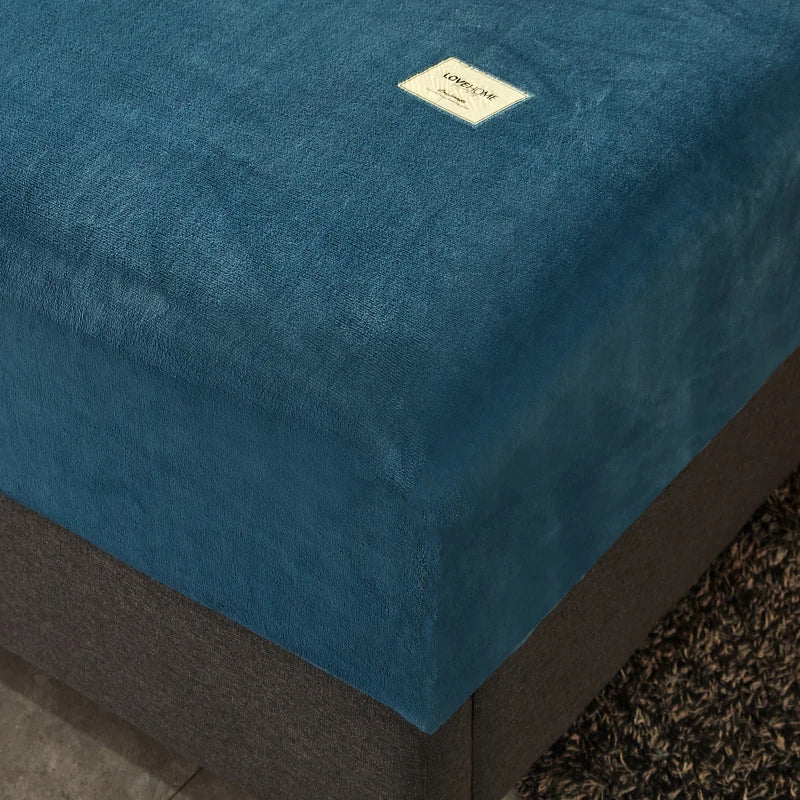 Blue mattress cover with a brand label on a bed