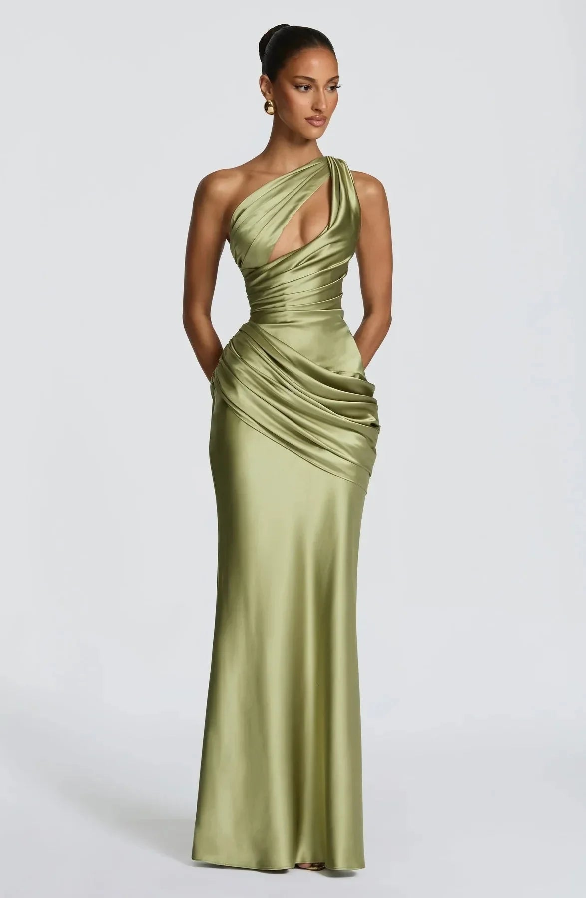 Woman wearing a green one-shoulder evening gown on a white background