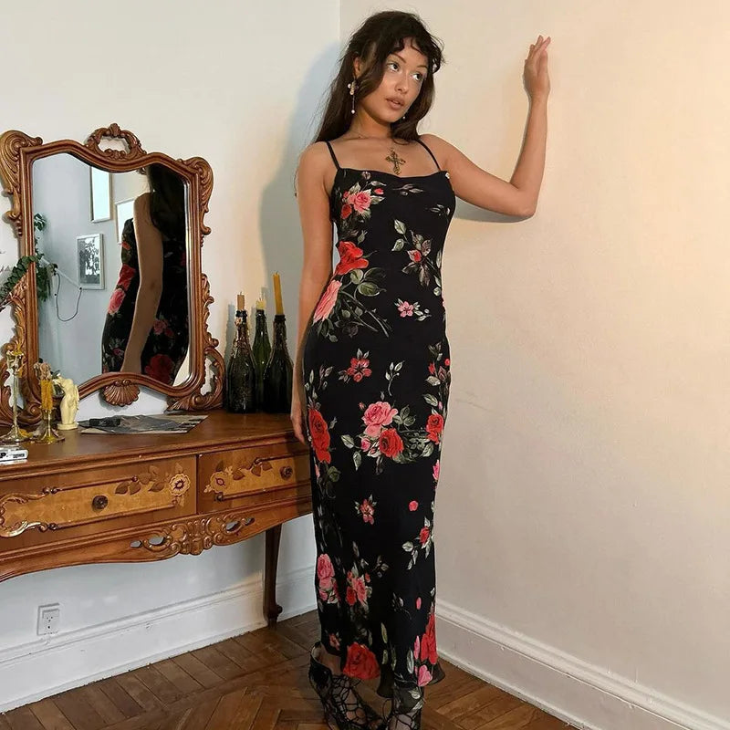 Woman in a floral dress standing in a room with a wooden dresser and mirror.