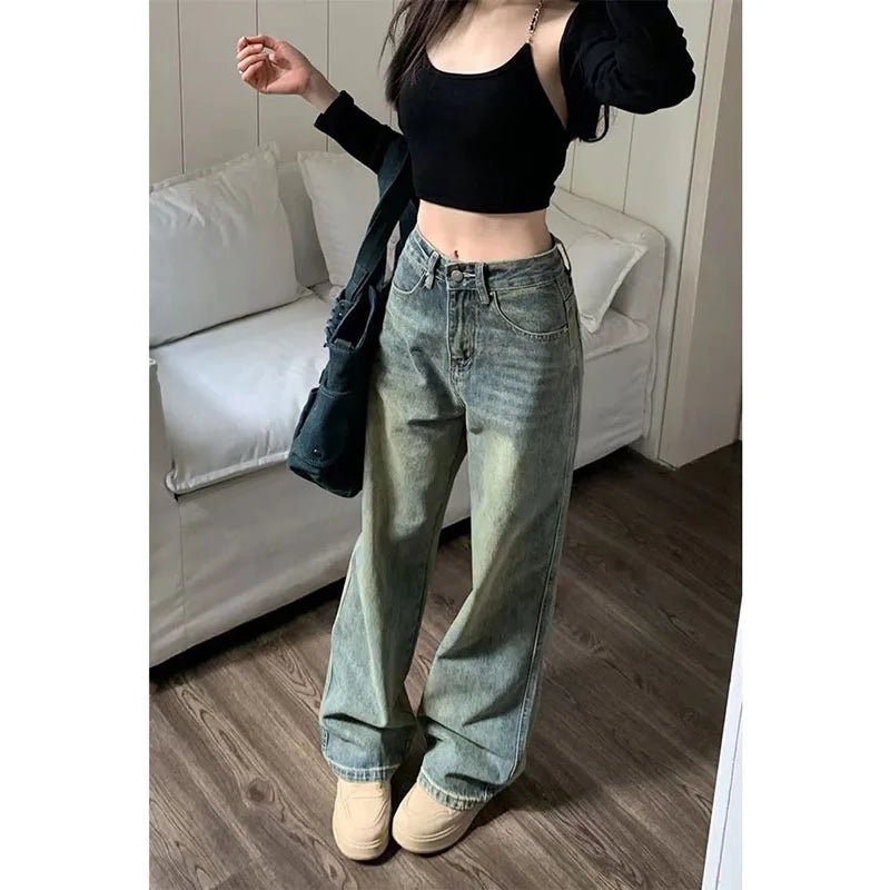 Person wearing a black crop top and light blue jeans in a living room setting.