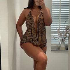 Person wearing a leopard print swimsuit in a room with a window and vase.