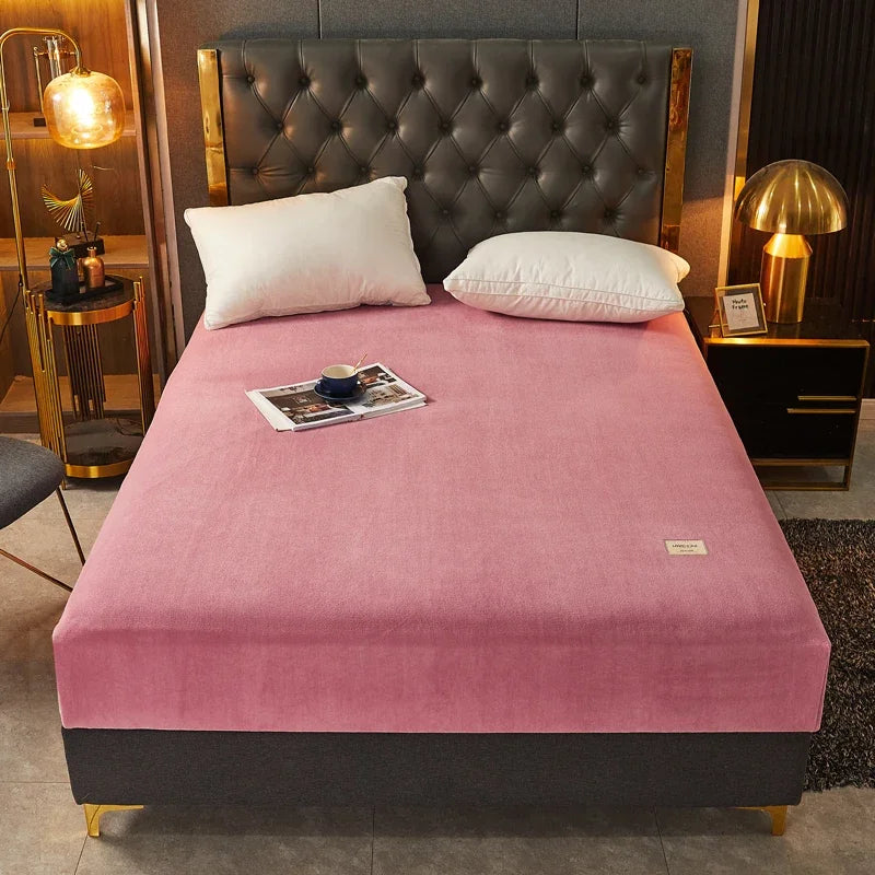 Pink mattress cover on a bed with a dark tufted headboard in a stylish bedroom.