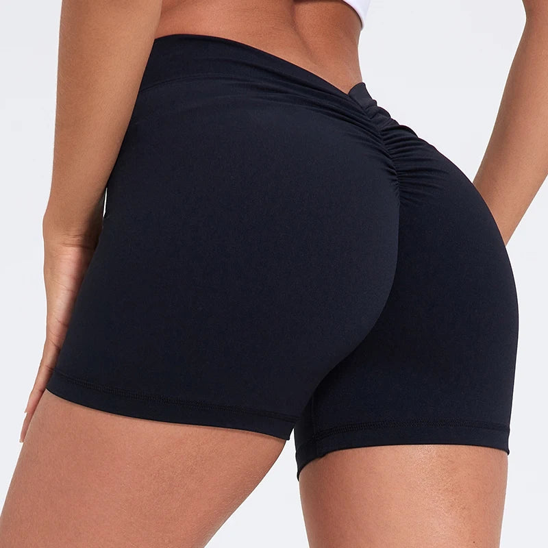 Black athletic shorts worn by a person on a white background