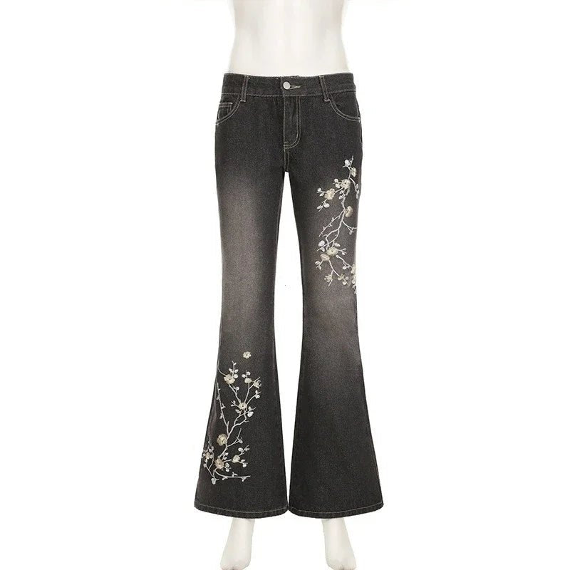 Black jeans with floral embroidery on a white background