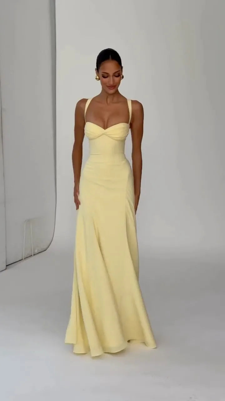 Woman wearing a yellow evening gown on a plain background
