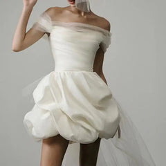 White off-shoulder wedding dress with a soft gray background