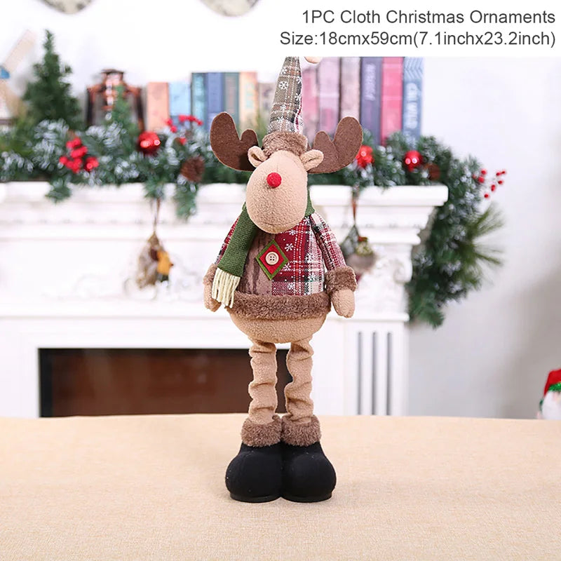 Plush reindeer Christmas ornament with a scarf in front of a decorated fireplace.