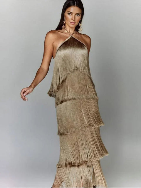 Woman wearing a gold fringe dress against a gray background