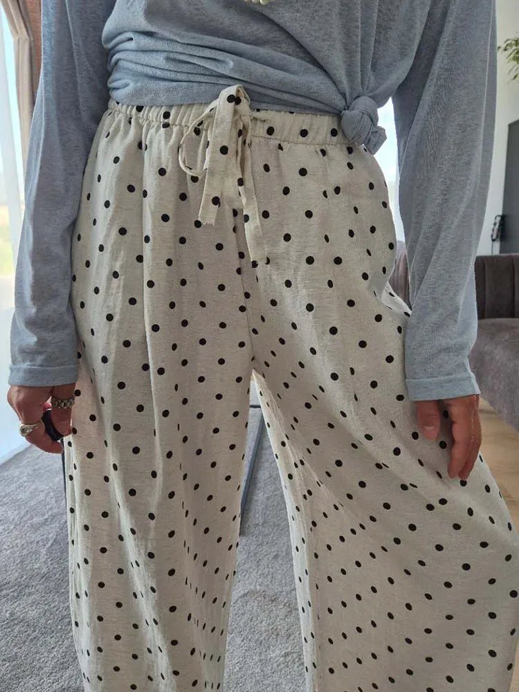 Person wearing beige pants with black polka dots and a gray long-sleeve shirt.