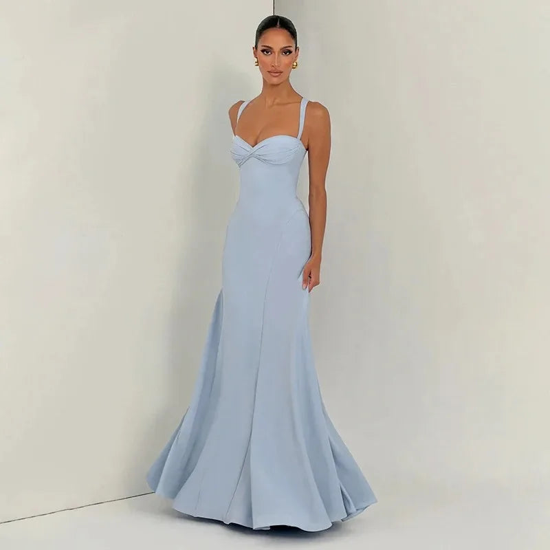 Woman wearing a light blue evening gown against a plain background