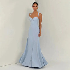 Woman wearing a light blue evening gown against a plain background