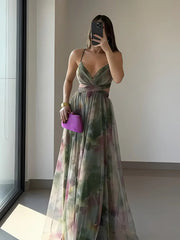 Woman in a floral dress holding a purple clutch in a minimal indoor setting.