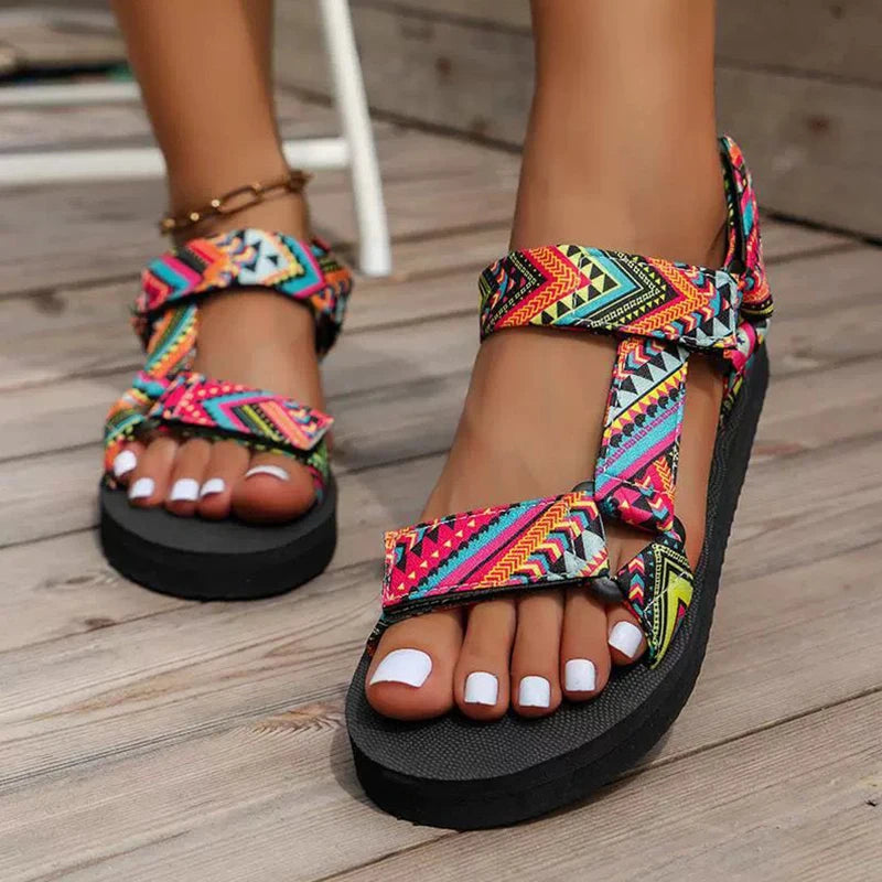Colorful tribal-patterned sandals on a wooden floor