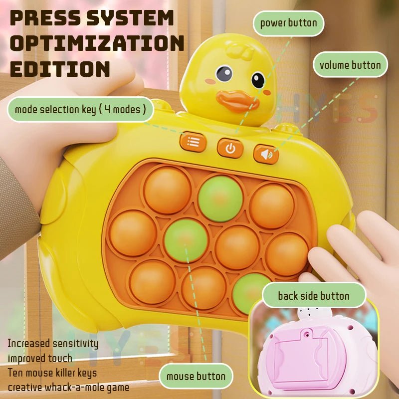 Yellow duck-shaped popper toy with labeled buttons held by a hand, on a blurred background.