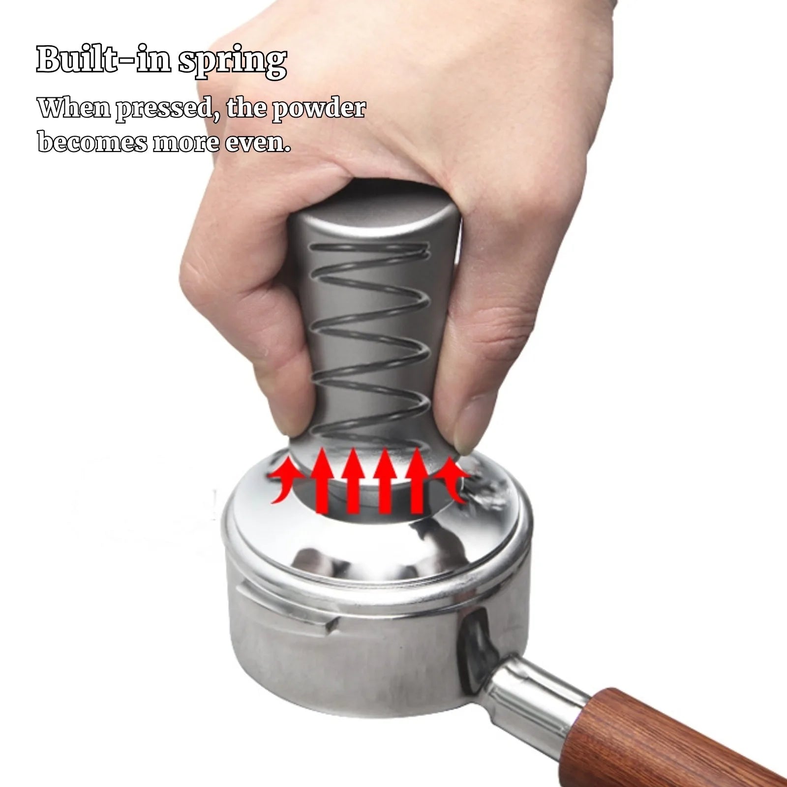 Hand holding a metal coffee tamp with a wooden handle, showing the built-in spring mechanism.