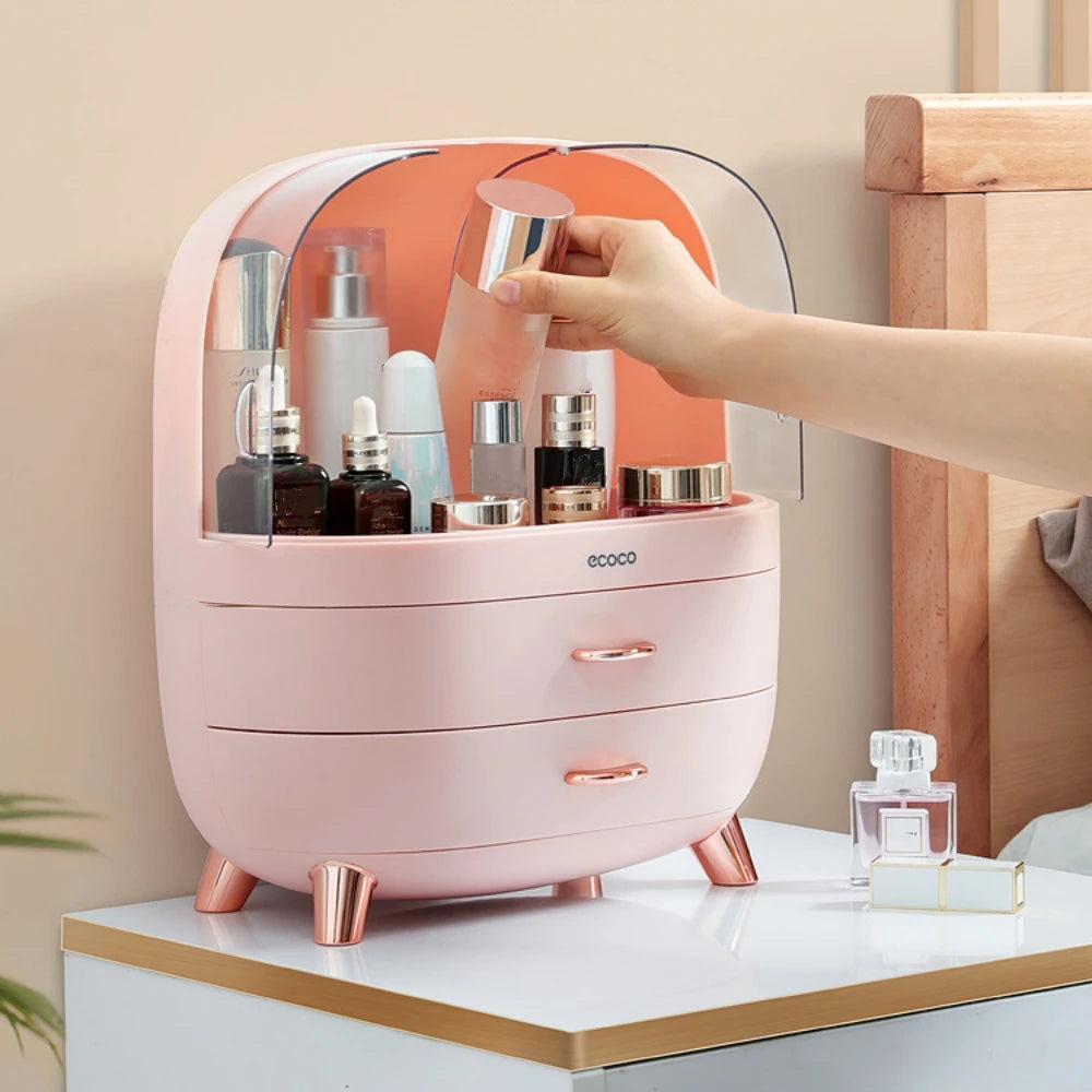 Pink cosmetic organizer with drawers, holding various skincare products, on a light-colored surface.