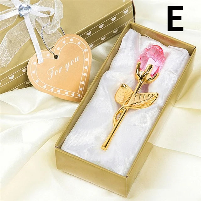 Gold and pink decorative item in a gift box with a heart-shaped tag.