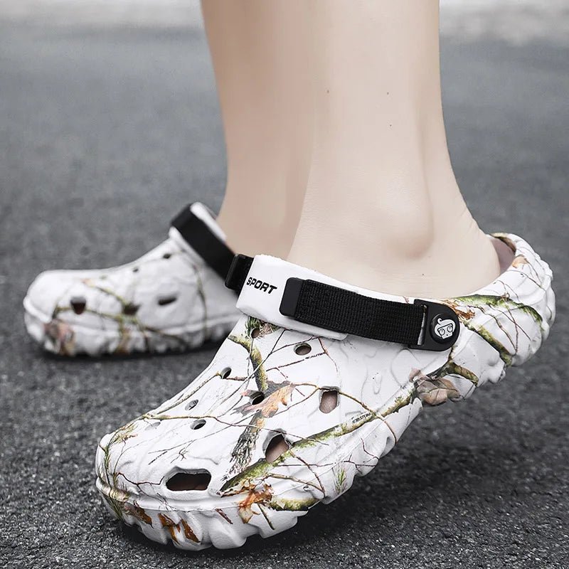 White camouflage sandals with black straps on a gray pavement background