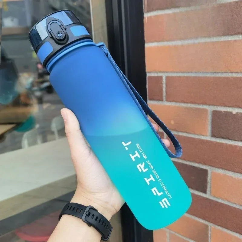 Gradient blue and green water bottle held by a person with a blurred background