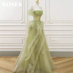 Green evening gown on a mannequin against a white wall.