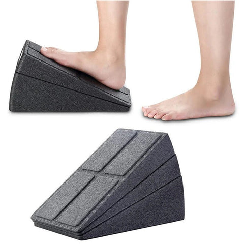 Black foot wedge being used with a person's feet on a white background