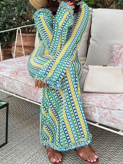 Person wearing a colorful patterned dress sitting on a couch outdoors.