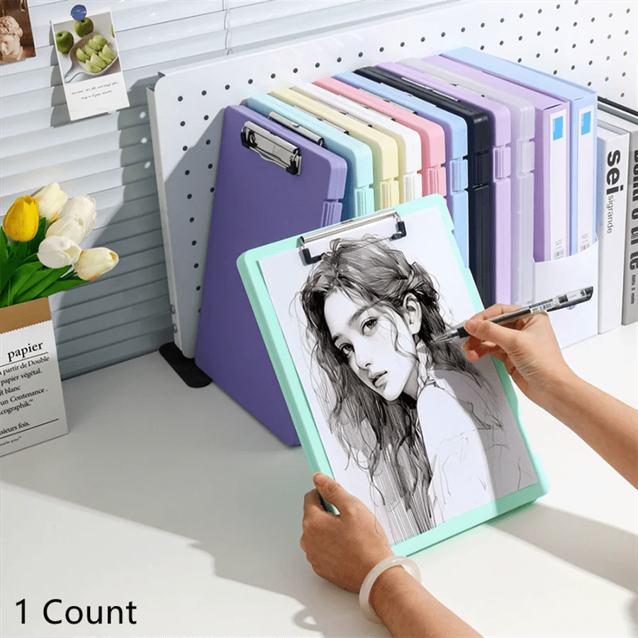 Person holding a drawing of a woman on a light green clipboard with other colorful clipboards in the background.