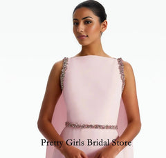 Woman wearing a pink evening gown with embellishments on a white background, branded 'Pretty Girls Bridal Store'.