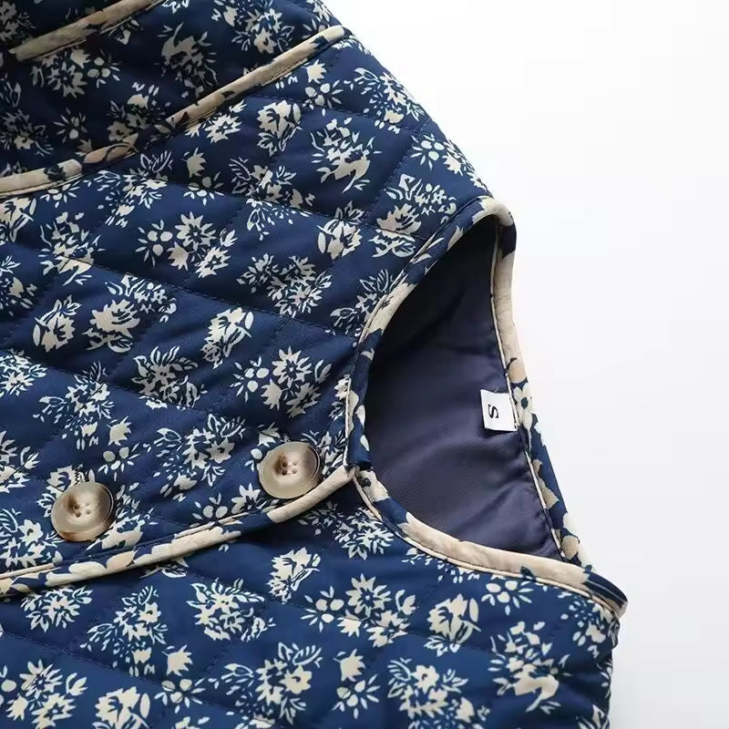 Blue quilt with white floral pattern on a white background
