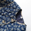 Blue quilt with white floral pattern on a white background