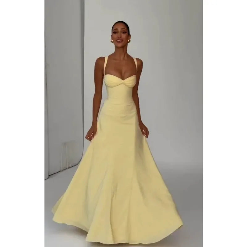 Woman wearing a yellow evening gown against a plain background