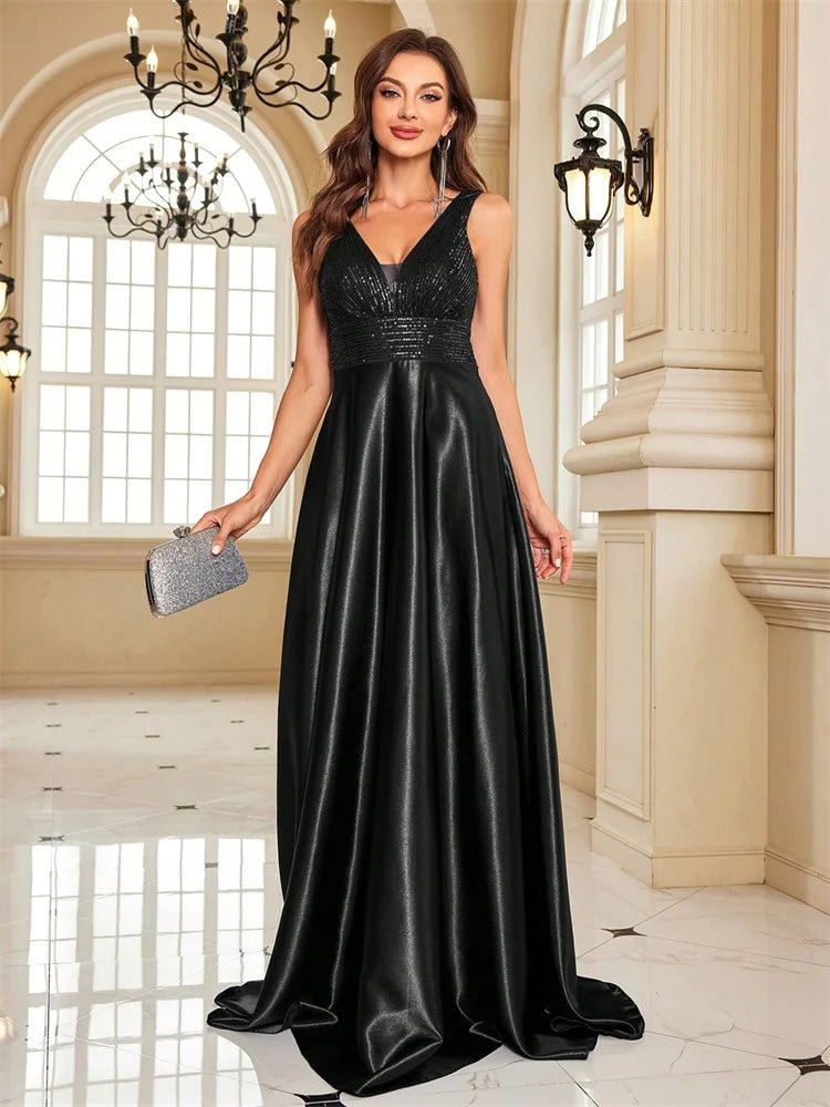 Woman in a black evening gown holding a clutch in an elegant interior setting.