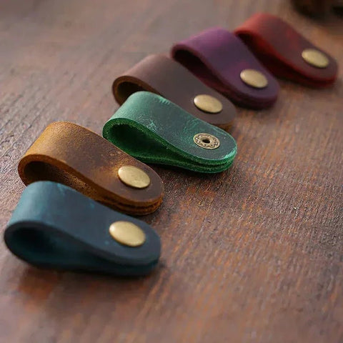 Set of leather key cases in various colors on a wooden surface