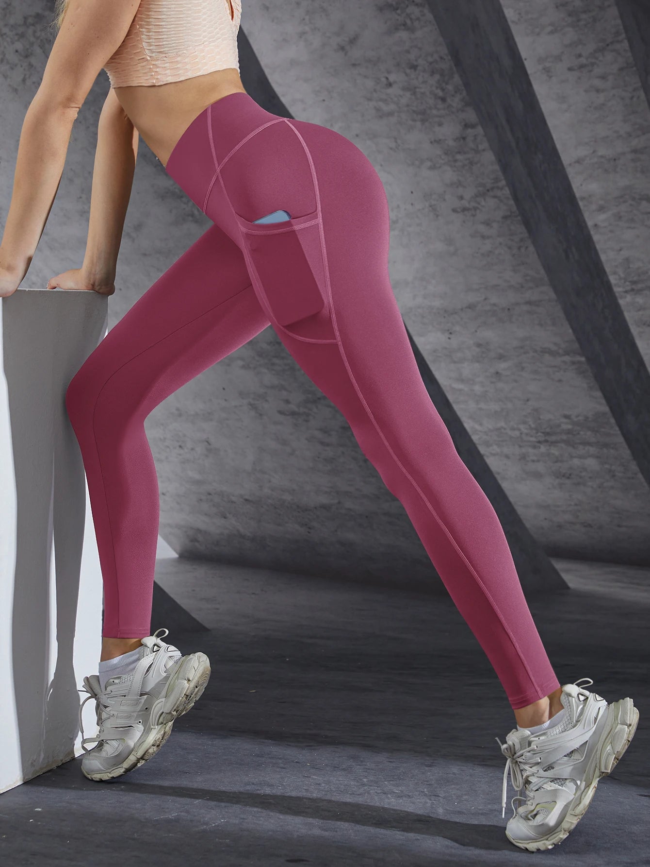 Person wearing maroon leggings with a gray background