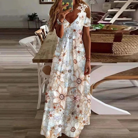 Woman in a floral dress taking a selfie in a dining room.
