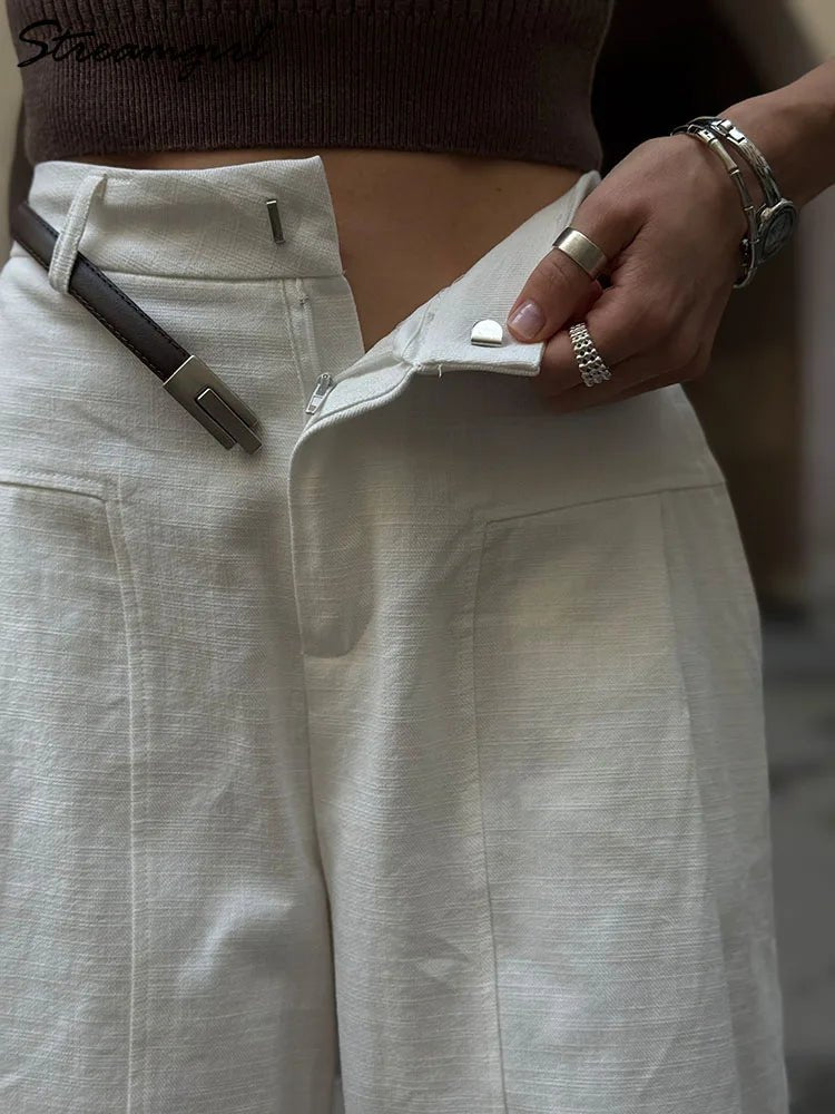 Person wearing beige pants with a focus on the waistband and a blurred background