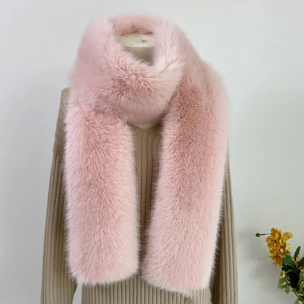 Pink fur scarf draped over a beige sweater on a white background with a small plant.