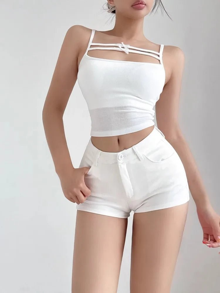 Person wearing a white sleeveless top and shorts on a plain background