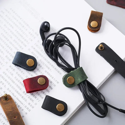 Leather cord ends with metal clasps on a white surface