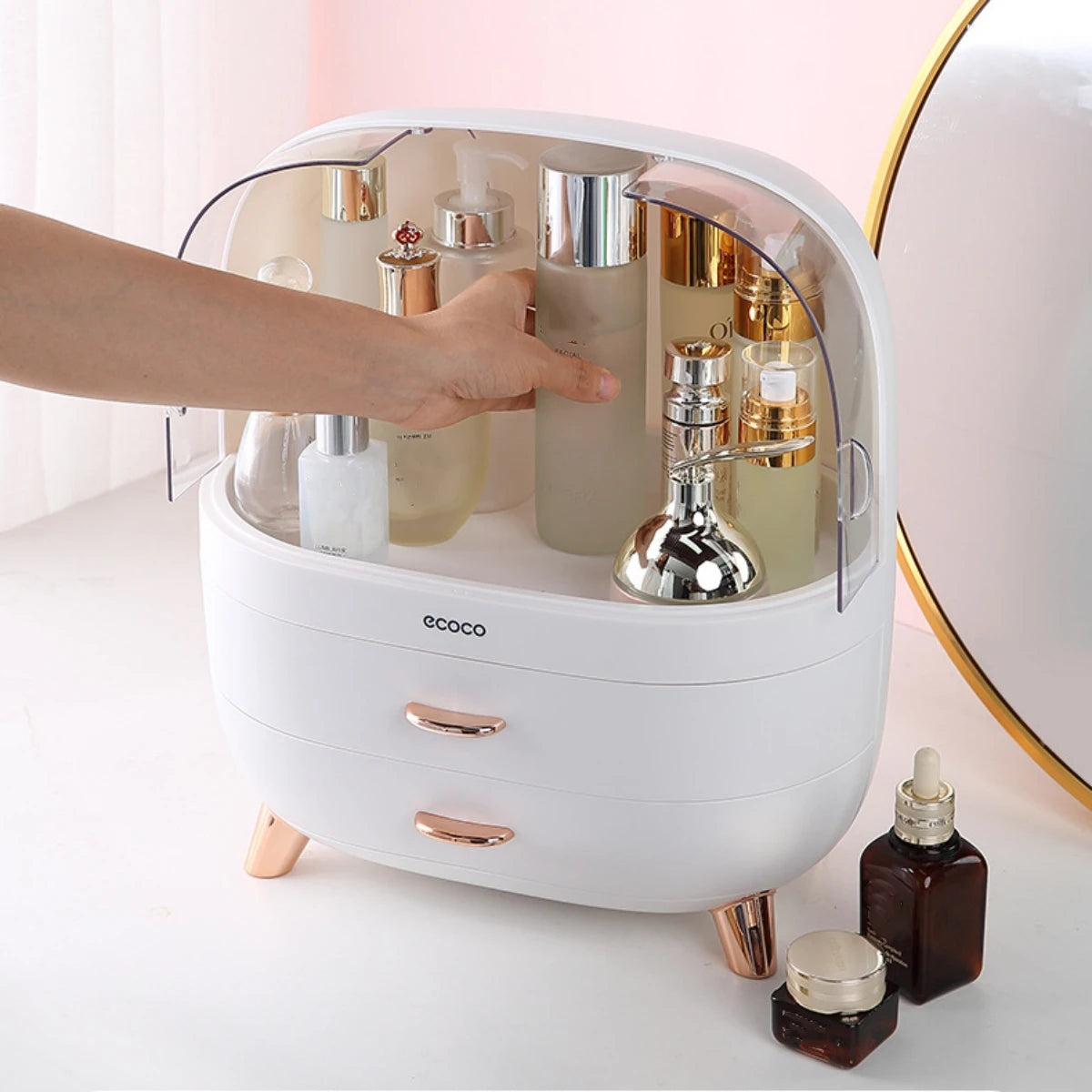 White cosmetic organizer with products on a light pink background