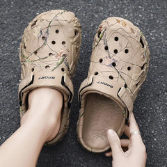 Beige sandals with camouflage pattern worn by a person on a dark surface