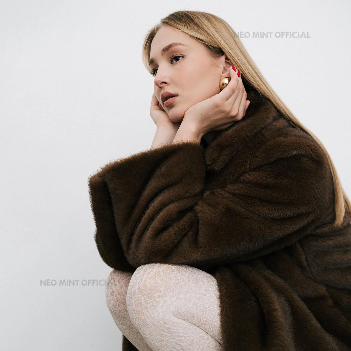Woman wearing a brown fur coat against a white background