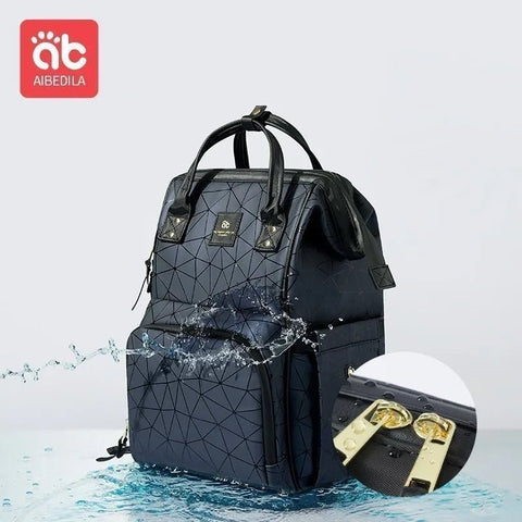 Black geometric-patterned backpack with water splash effect on a light gray background