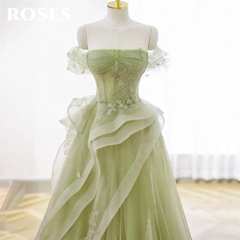 Green evening gown on a mannequin with a blurred background