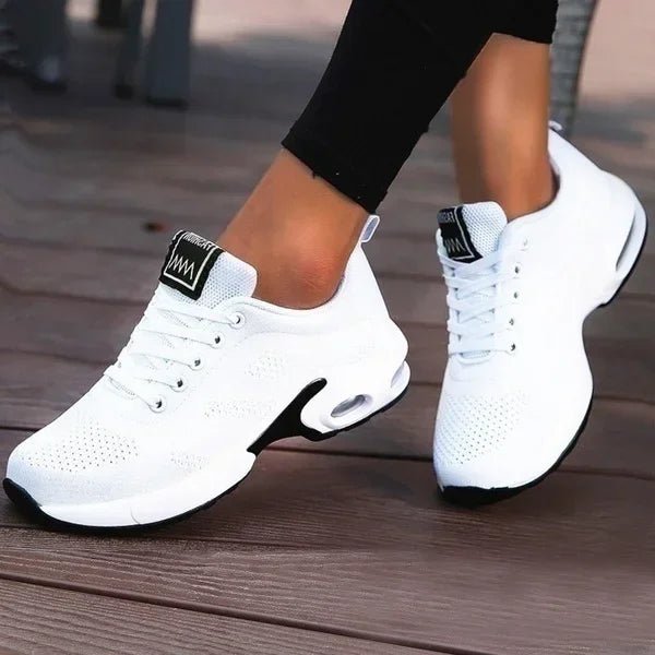 White sneakers with black accents on a wooden floor