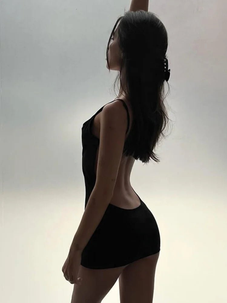 Silhouette of a person wearing a black sleeveless top and shorts against a light background