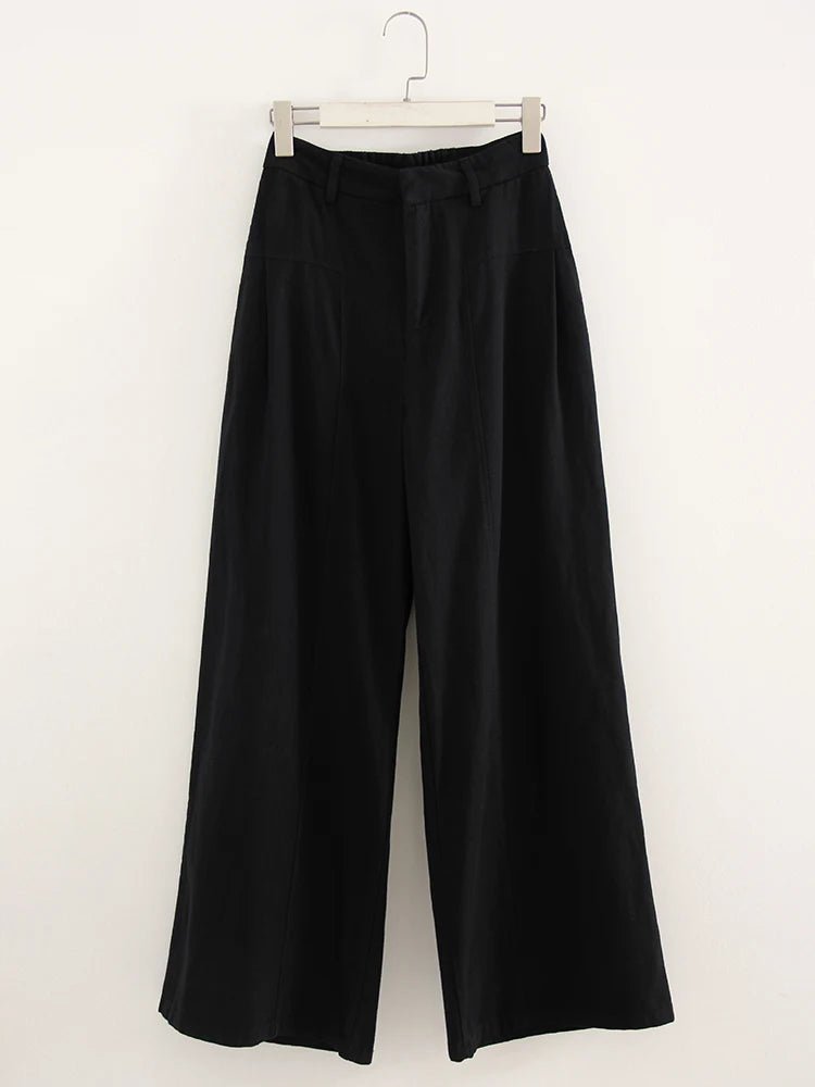 Black wide-leg pants on a hanger against a white background
