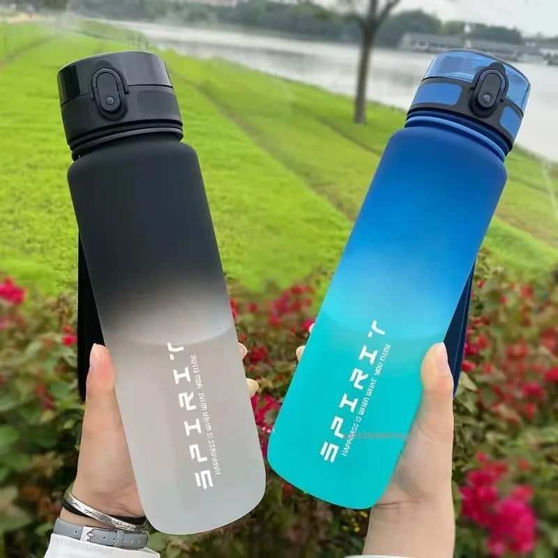 Two gradient water bottles held in hands with a natural background